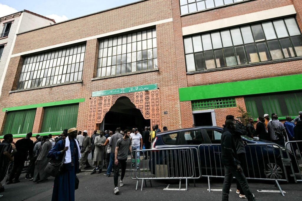 Exterior of the Al-Islah Mosque in Montreuil, France, with worshippers gathered outside
