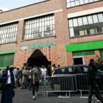 Exterior of the Al-Islah Mosque in Montreuil, France, with worshippers gathered outside