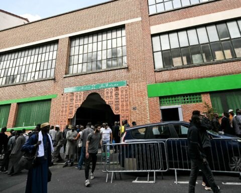 Exterior of the Al-Islah Mosque in Montreuil, France, with worshippers gathered outside