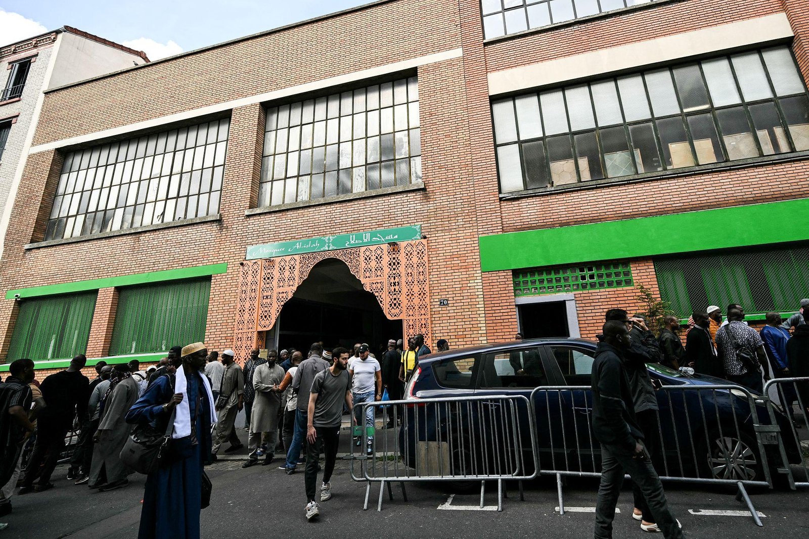 Exterior of the Al-Islah Mosque in Montreuil, France, with worshippers gathered outside