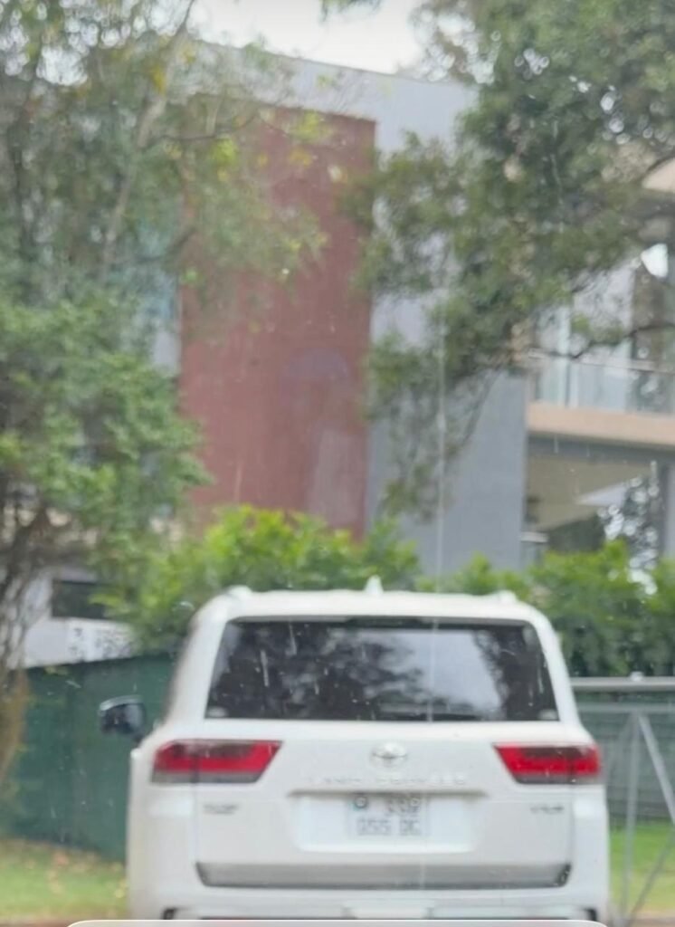 Adut Kiir and the Unverified Nairobi Property Claim 2 White Toyota SUV parked outside a multi-storey building partly obscured by trees and vegetation.
Скопировать